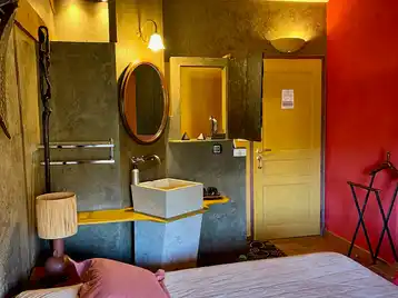 Afrikaanse kamer - Kameringang met enkele wastafel en aangeschakelde lampen boven de spiegel