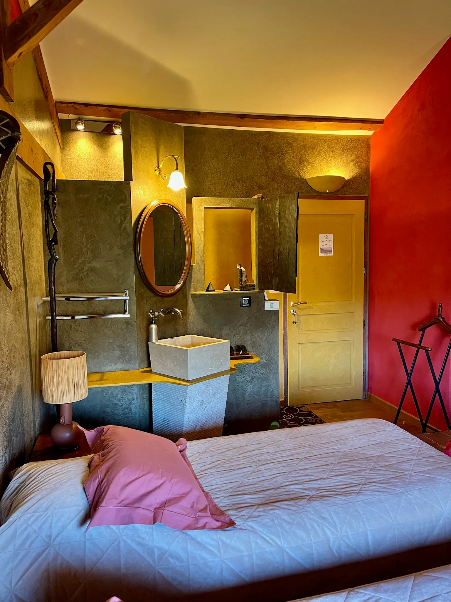 Afrikaanse kamer - Kameringang met enkele wastafel en aangeschakelde lampen boven de spiegel