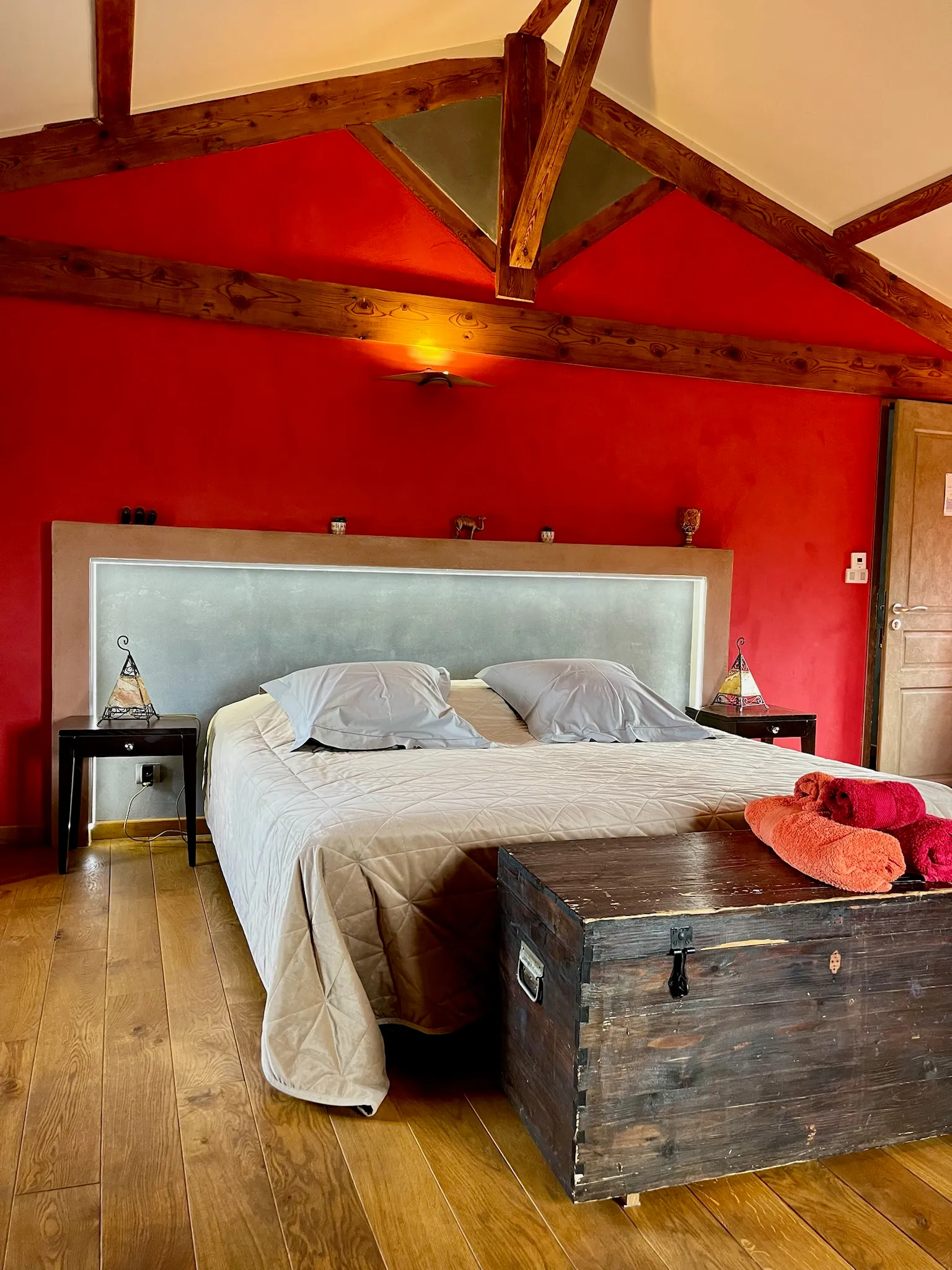 Moroccan suite - Double bed seen from the front with illuminated headboard and towels arranged on the chest at the foot of the bed