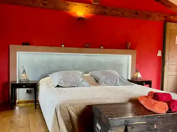 Moroccan suite - Double bed seen from the front with illuminated headboard and towels arranged on the chest at the foot of the bed