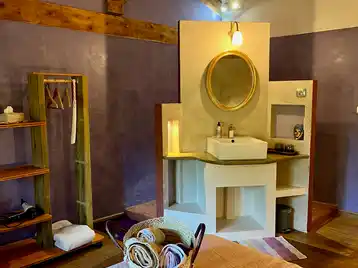 Toscaanse kamer - Bergruimte voor kleding met enkele wastafel en tadelakt-douche op de achtergrond