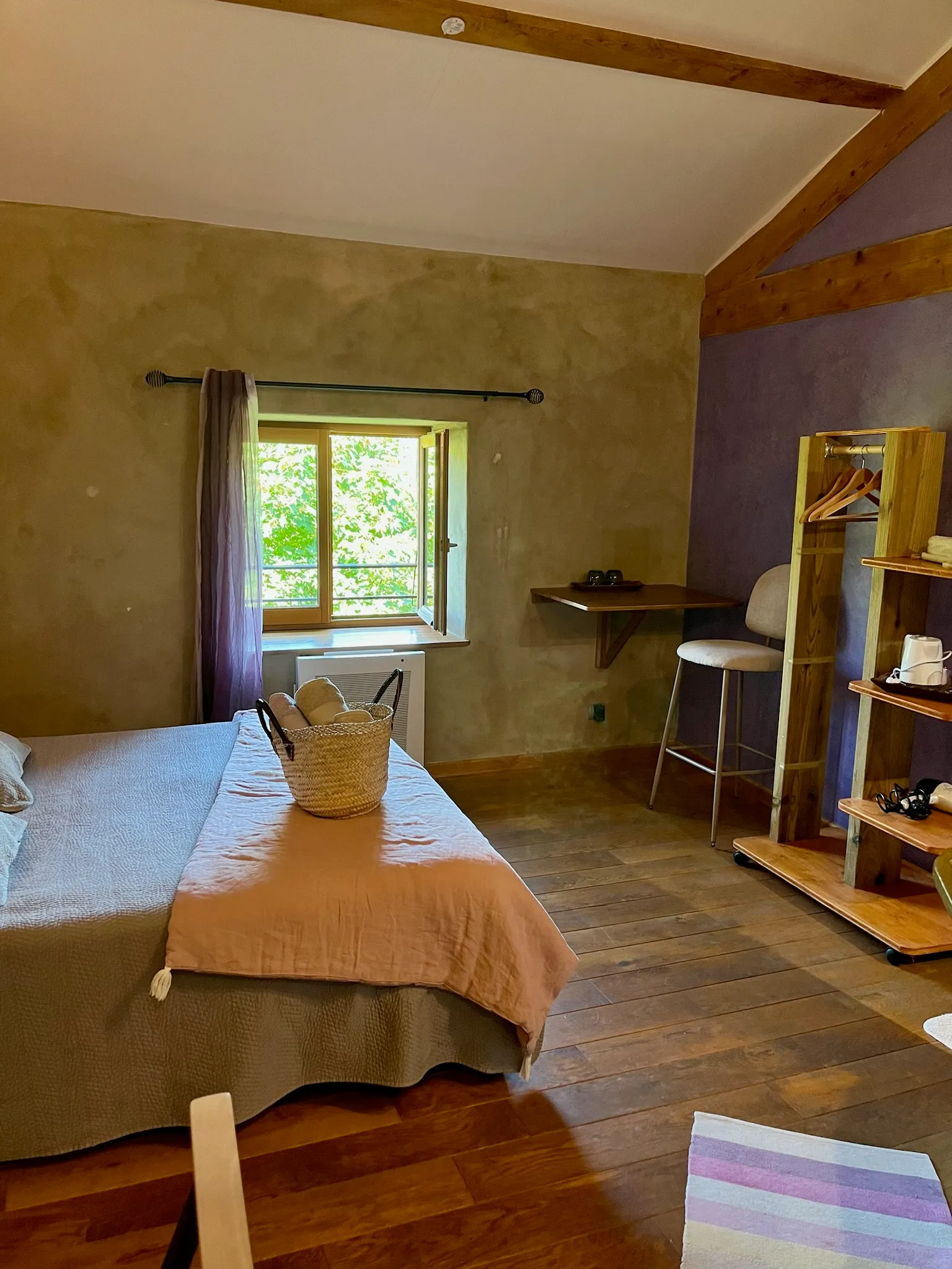 Toscaanse kamer - Kamer badend in licht met zicht op de tuin, handdoeken op het bed en bergruimte voor kleding