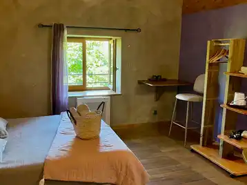 Toscaanse kamer - Kamer badend in licht met zicht op de tuin, handdoeken op het bed en bergruimte voor kleding