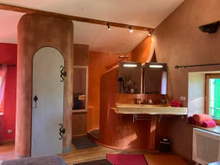 Photo d'une chambre sur laquelle nous voyons l'espace douche, double vasque et la porte des toilettes